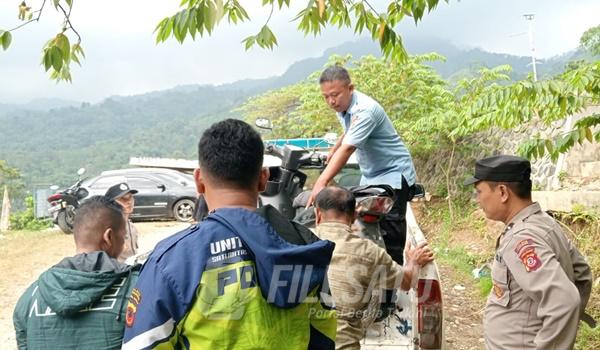 Petugas Kepolisian dibangtu warga setempat saat evakuasi korban terjun ke jurang