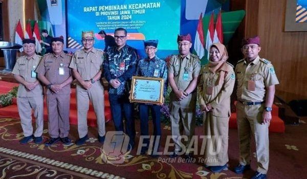 Pj Sekda Guntur Priambodo saat menerima penghargaan di Surabaya