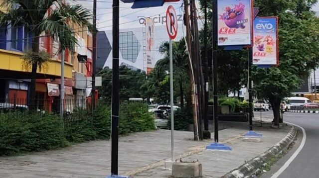 Tiang reklame milik perusahaan swasta berdiri tepat di atas guiding block